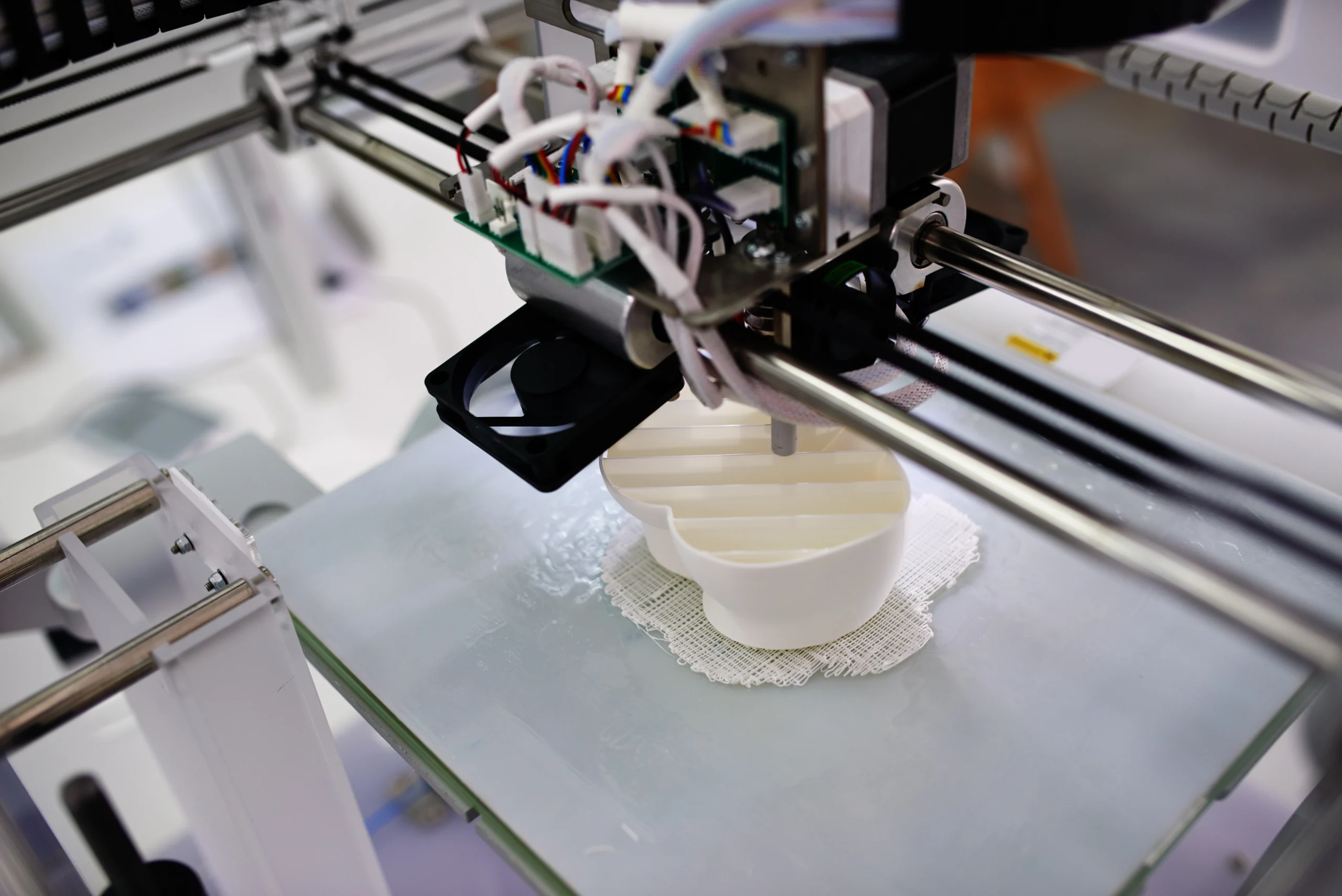 3D printer extruding a white part with support material